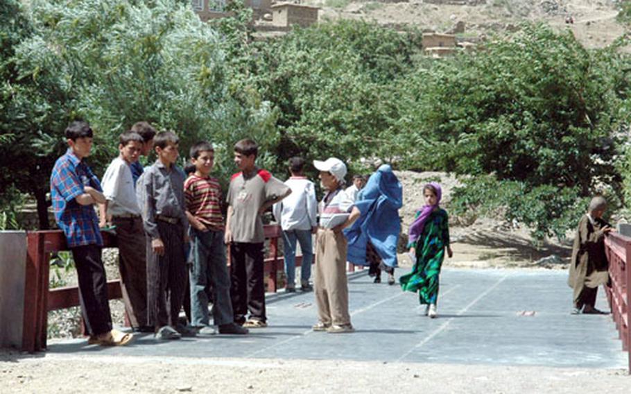Young Afghans gather on the newly finished bridge outside of Nawaj, Afghanistan, on Tuesday. The bridge was built by local contractors using funds from the Bagram Provincial Reconstruction Team.