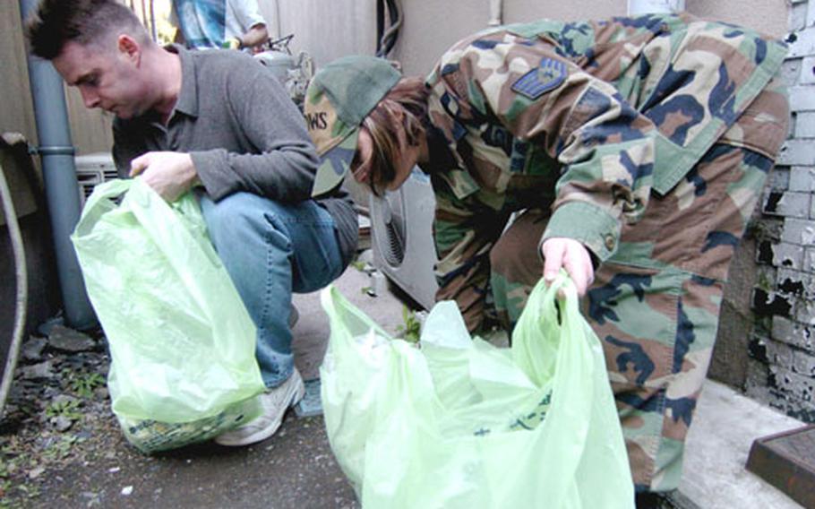 Members of the 20th Operational Weather Squadron clean up debris outside the gate of Yokota Air Base, Japan, in March. Staff Sgt. Kimberly Green and 1st Lt. Ric Brunet thought of the project, which soon became a company activity. Green said, “You can see all the Japanese locals looking at us, wondering what we’re doing. It’s nice to get out and show them that we care about the community.”