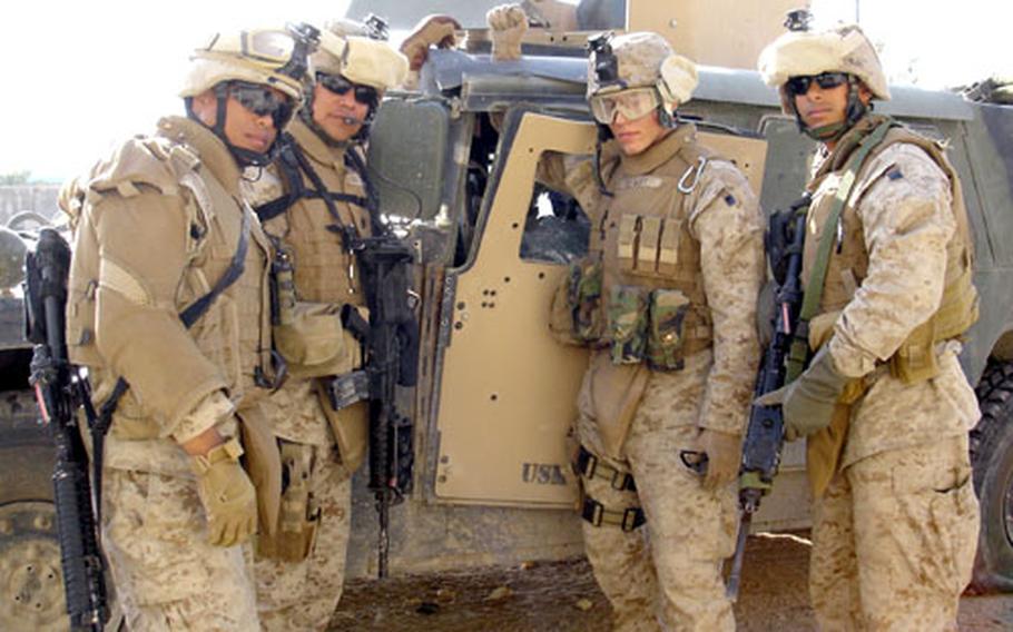 From left, Marine Cpl. Hari-Das Felix, Staff Sgt. Alberto PerezTorres, Cpl. Jeremy Newby and Cpl. Ernesto Mangual stand beside their Humvee in April after a live mortar round passed through their vehicle in Iraq before it hit the ground and exploded.