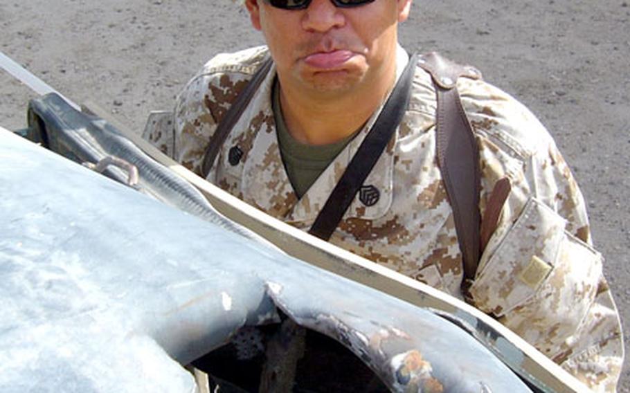 Staff Sgt. Alberto M. PerezTorres stands beside his Humvee, which was hit by a live mortar round. PerezTorres and three other Marines in 1st Battalion, 1st Marine Regiment escaped the attack with minimal injuries.