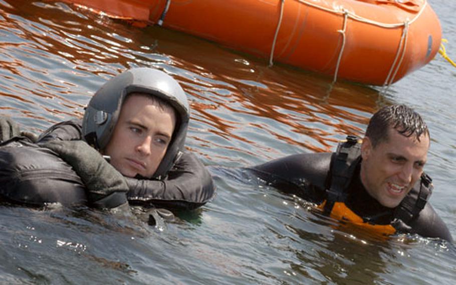 Instructor Staff Sgt. Tony Raciborski, right, stays in the water with F-16 pilot Capt. Scott Wuenstel during water survival training Friday in Lake Ogawara at Misawa Air Base, Japan.