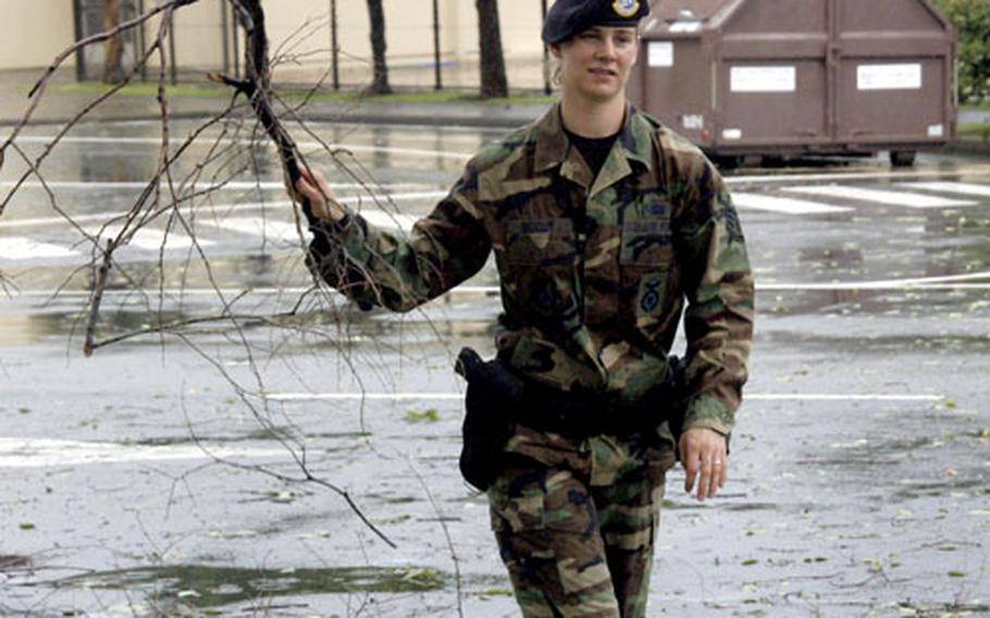 Staff Sgt. Alexandra McCoy of the 374th Security Forces Squadron helps clear a road near Yokota West Elementary School littered with limbs, branches and leaves after a powerful thunderstorm tore through Yokota Air Base on Saturday.