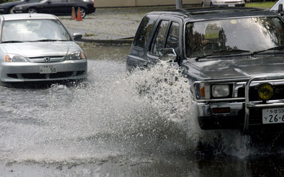 Motorists drive through a partially flooded area near Tomodachi Lanes bowling center on Saturday after a powerful thunderstorm tore through Yokota Air Base, Japan.