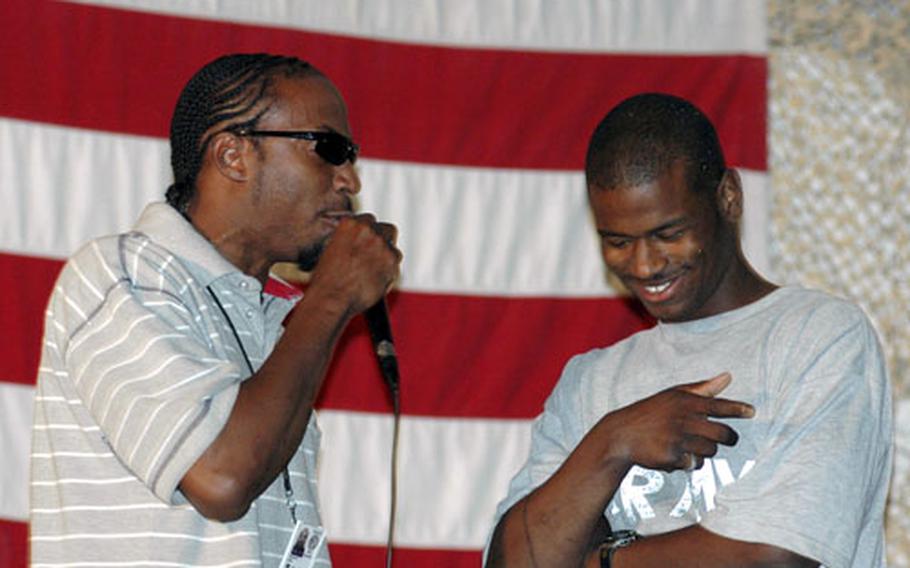 Spc. Maladrique Wilson, right, a soldier serving with Combined Joint Task Force–250, laughs as he listens to KBR contractor Wilton Jackson’s putdowns during a freestyle rap battle Thursday night at Bagram Air Base in Afghanistan. The competition is the highlight of the base’s weekly open-mic nights.