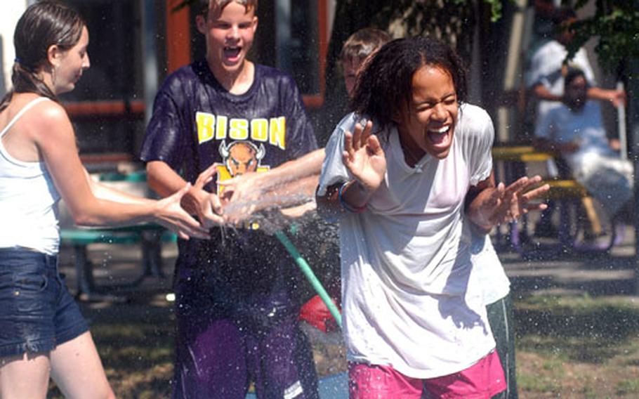 The heat wave in Europe is not bothering these kids enrolled in the Mannheim, Germany, Youth Services’ summer camp. Justin Markle, center, sprays Bria Harper, right, with water as Amy Penton, left, gives him a hand.