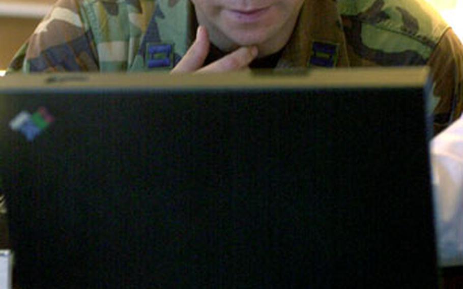 Capt. Jason Simmons watches a demonstration at the Ericsson booth at the 2006 Technology Expo at Ramstein Air Base’s Officers’ Club on Tuesday.