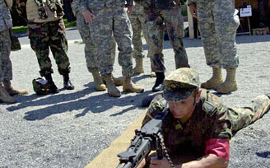 A German 12th Panzer Brigade soldier shows soldiers from Headquarters Headquarters Troop, 2nd Cavalry Regiment how to fire a German MG3 machine gun on Tuesday.