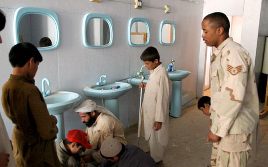 Staff Sgt. William Johnson directs students practicing their plumbing skills during classes Tuesday run by the Qalat provincial reconstruction team.