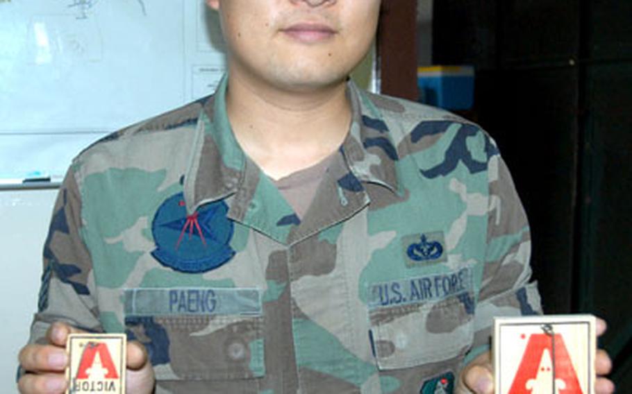 Staff Sgt. Seung Paeng, noncommissioned officer in charge of pest management at Misawa Air Base, Japan, holds up two traps used for rodents: The smaller one is for house mice, the larger for rats. The four-person shop is busiest from March to November, controlling insects, spiders and weeds, while rats are a cold-weather nuisance.