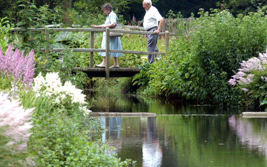 Visitors to the Gooderstone Water Gardens make their way across one of the 13 bridges inside the park.