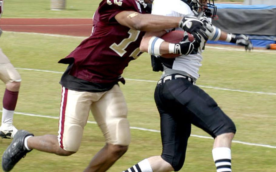 Airman 1st Class Byron Washington, left, a production controller with 100th Civil Engineering Squadron, who is also a safety and wide receiver for the MCP Ipswich Cardinals, tackles a Kent Exiles running back.