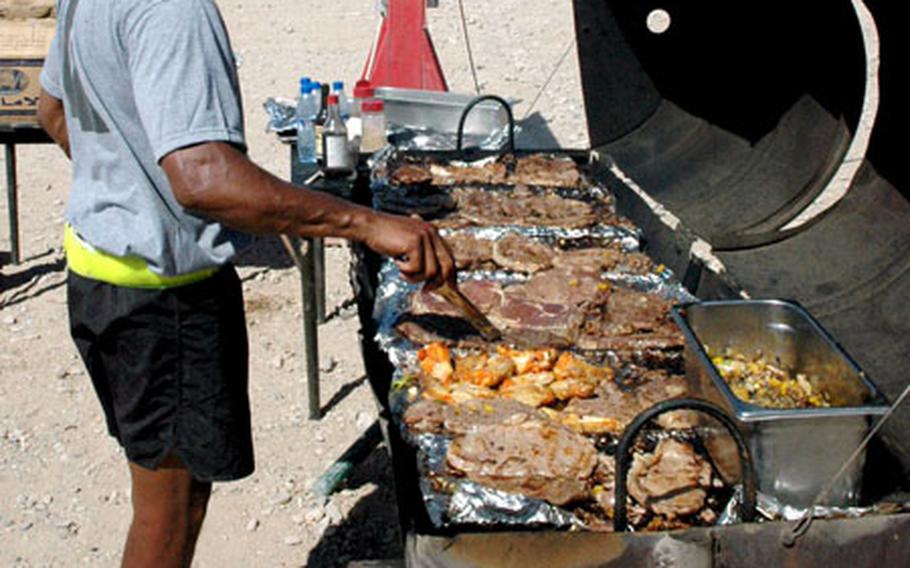 Sgt. 1st Class Robert Cordell of the 330th Movement Control Battalion flips some steaks during a cookout Sunday for members of the Surface Deployment and Distribution Command at Kandahar Airfield in Afghanistan. The barbecue was a thank you to the troops for their recent work.