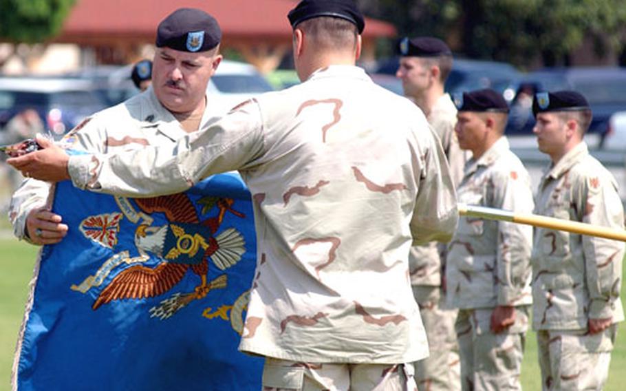 The colors of the 1st Military Intelligence Battalion are flying again in Wiesbaden, Germany, as Command Sgt. Major Michael Allen, left, and battalion commander Lt. Col. Michael Popovich uncase them at a welcome home ceremony at the airfield on Thursday.