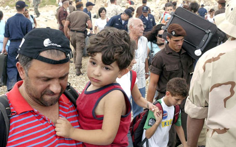 Evacuees wait at a shorefront processing area in Beirut on Friday, where U.S. Navy sailors helped load them onto landing craft to ships bound for Cyprus.