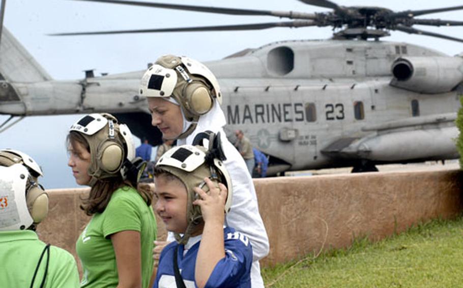 Evacuees from Beirut, Lebanon, wait to board a U.S. Marine helicopter Friday at the U.S. Embassy.