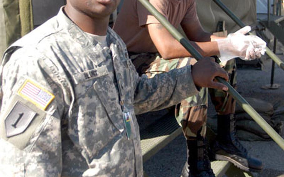 Cpl. Kenneth Blunt, left, and Spc. Bobby Webb of the 454th Replacement Company, Mannheim, Germany, take a break after serving breakfast Friday at the Novo Selo Training Camp in Bulgaria.