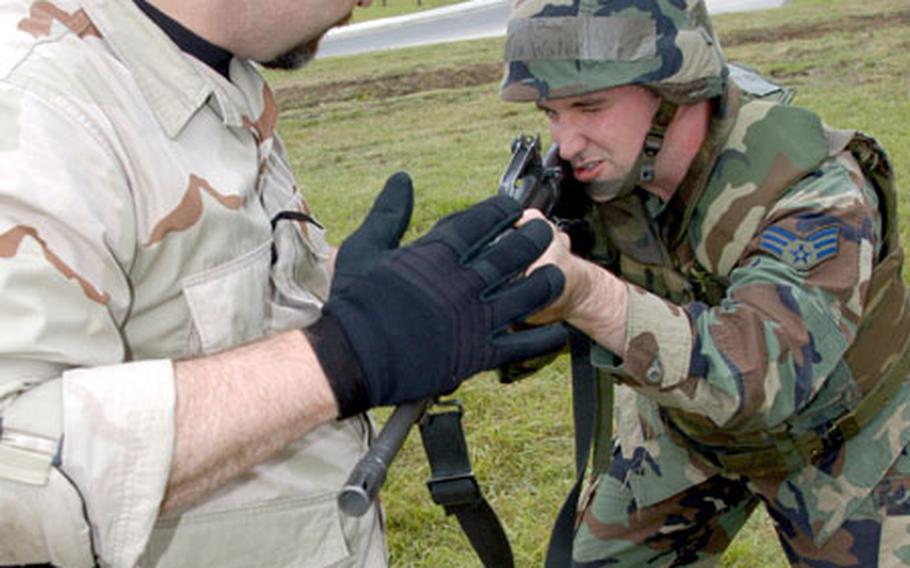 Instructor Adam Smith, a former Navy SEAL, works with Senior Airman John Walker in the correct stance to use when engaging the enemy.
