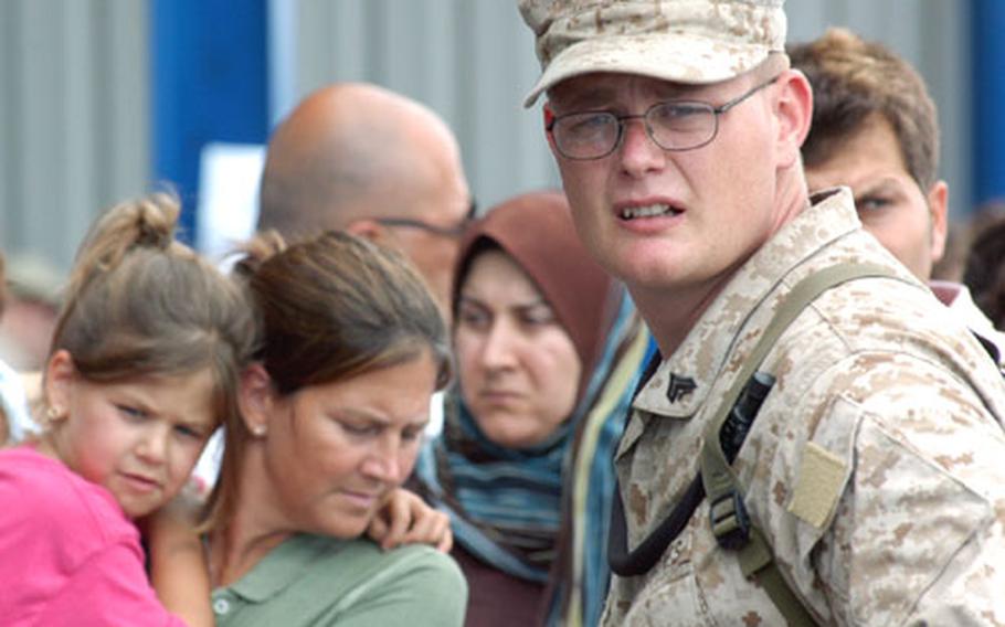 Cpl. Justin Muir, from the 24th Marine Expeditionary Unit Service Support Group, stands with crowds of American citizens waiting to be evacuated from Beirut near the U.S. Embassy on Friday.