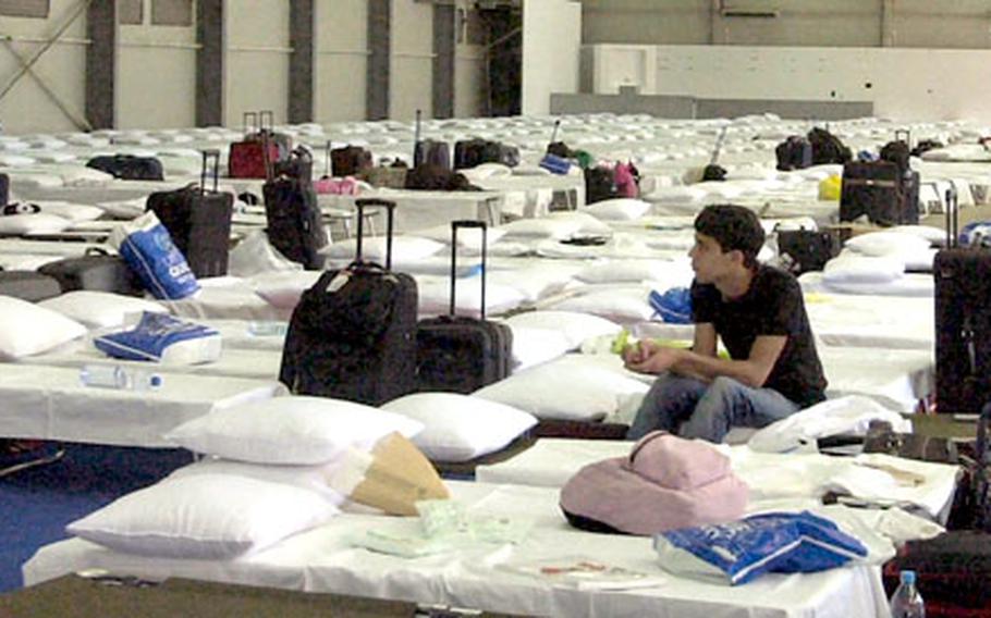 An American evacuee from Lebanon sits on a cot among hundreds of empty beds at the Cyprus International Fairgrounds in Nicosia, Cyprus on Friday.