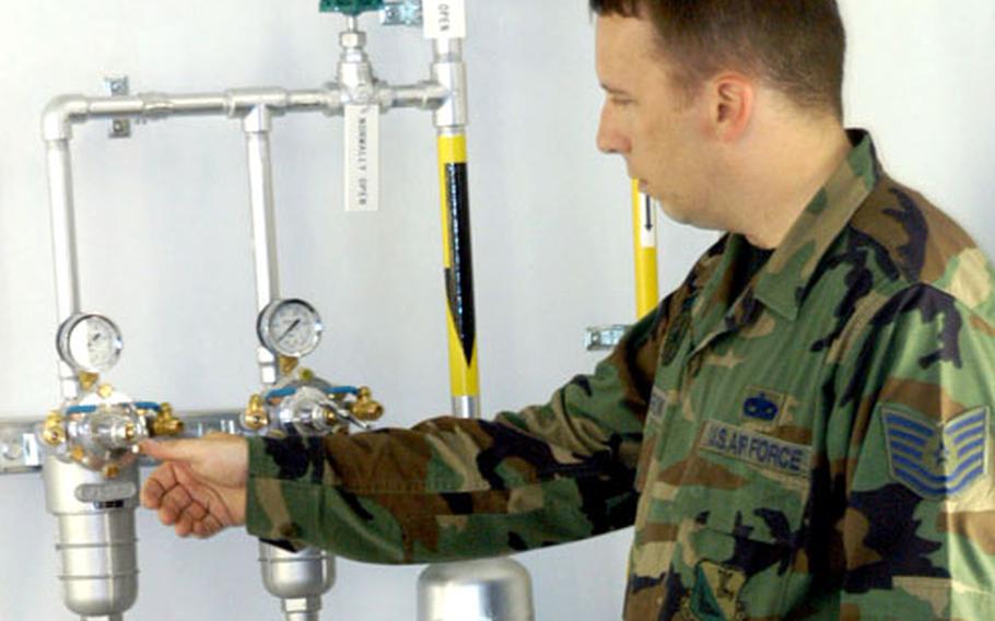 Tech. Sgt. Robert O’Harrow checks a compressor gauge in the paint booth of a new $8.3 million hangar at Yokota Air Base, Japan.