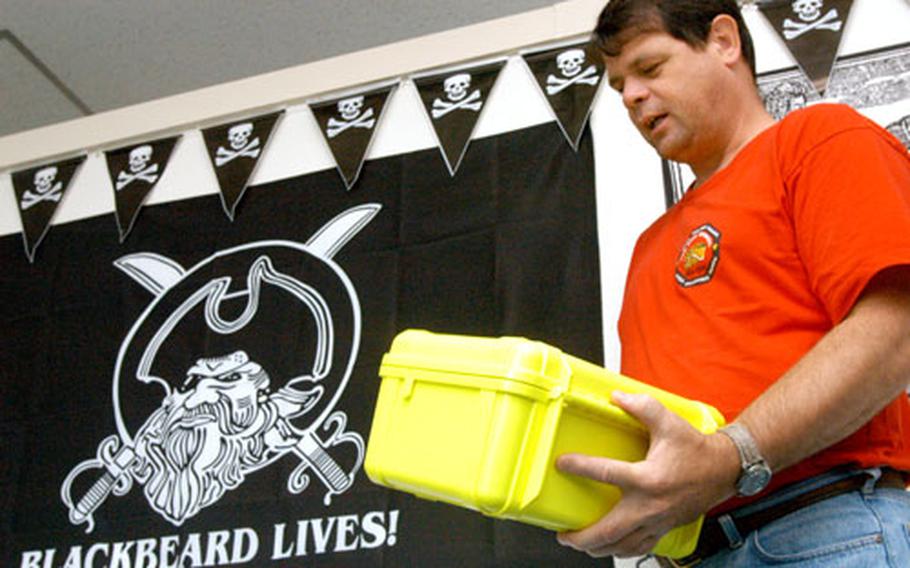 Green Bay Marina Manager Dennis Lindemann holds a box that is similar to boxes contestants will seek in Yokosuka’s Land and Sea Race slated for Saturday.