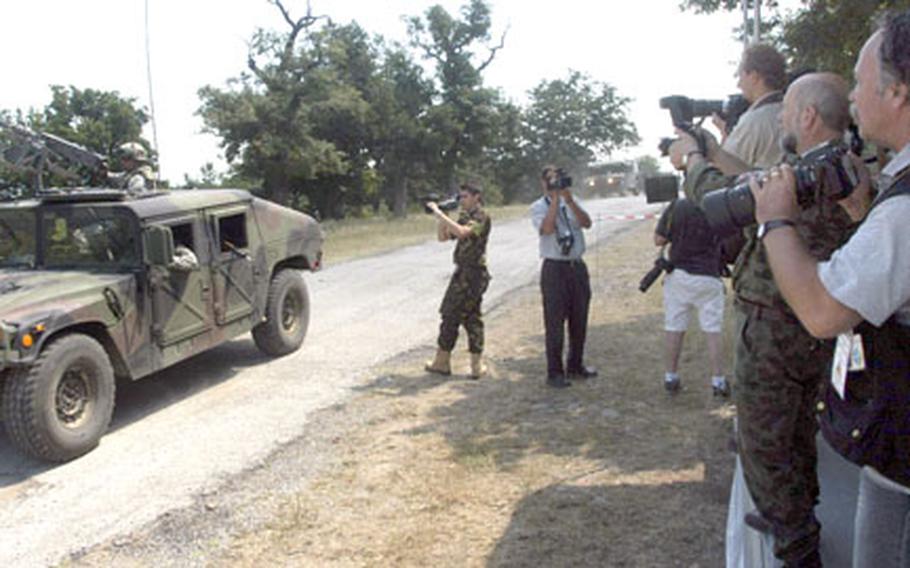 Reporters and photographer from Bulgaria and Romania take pictures from a viewing stand on Wednesday during a demonstration by U.S., Bulgarian and Romanian forces at the Novo Selo Training Area in southeastern Bulgaria.