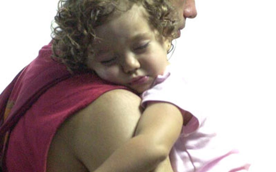 A girl sleeps in the arms of her father after arriving in Limassol, Cyprus.