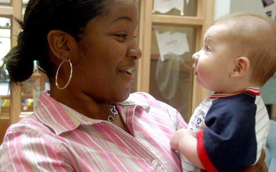 Latoya Suber, a program technician, cradles 4-month-old Jimmy Elliot at RAF Mildenhall’s Child Development Center. Suber has been working at the center for more than five years and knows that child care is not just about changing diapers.