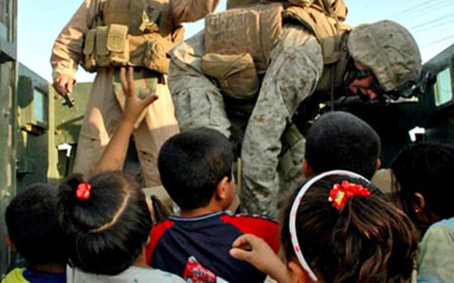 Marines from Company C, 1st Battalion, 25th Marine Regiment toss toys and candy to children during a recent civil engagement mission in Fallujah.