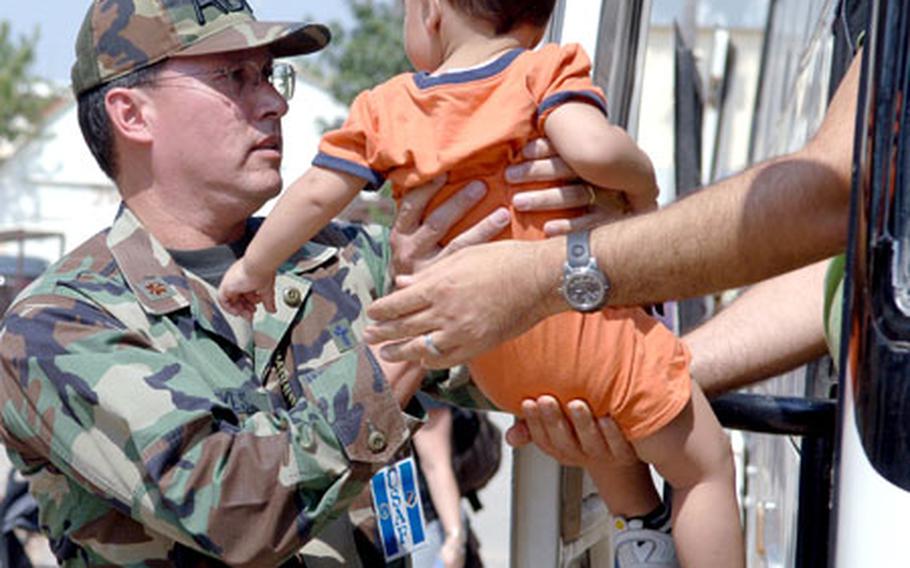U.S Air Force Maj. Kenneth Reyes, 39th Air Base Wing chaplain, holds a toddler, one of many American citizens who departed Lebanon and arrived at the 39th Logistics Readiness Squadron&#39;s Deployment Processing Center at Incirlik Air Base, Turkey on Monday.