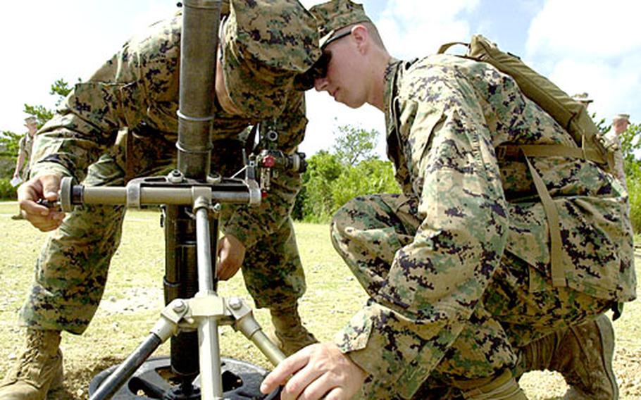 Lance Cpl. Robert Hernandez, 22, of Boise, Idaho, and Lance Cpl. Kyle Gist, 20, of Grapevine, Texas, adjust the settings of Gun 1, one of two 60mm lightweight mortars on the gun line at a Camp Hansen firing range on Wednesday.
