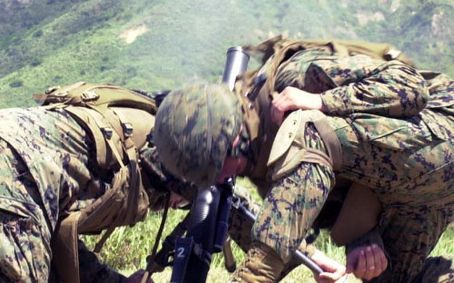 Ferreira and Garvey hunker down as their 60 mm lightweight mortar shoots a high-explosive round.