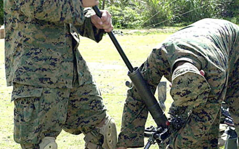 Lance Cpl. Rudy Chavez, 20, of Kansas City, Mo., punches the bore of the 60mm lightweight mortar before the Marines fire off rounds, to ensure it is clear of obstructions. Pfc. Shaun Garvey, 19, of Indianapolis, held the weapon steady during the process.