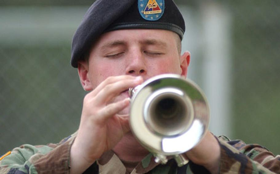 Spc. Michael Holzhausen of the 1st Armored Division Band plays "Taps" at the memorial ceremony for Sgt. Mark Vecchione Wednesday afternoon at Friedberg, Germany.