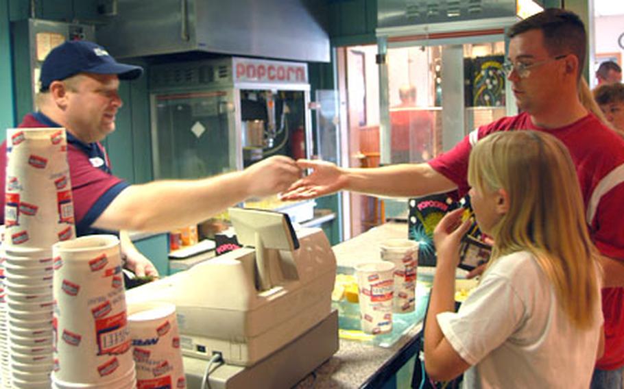 Mike Janney and his daughter Kirstyn buy goodies at Rammers Theater, which, along with other businesses at the Babenhausen post, is closing.