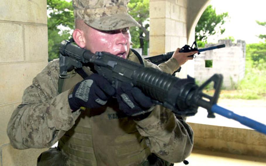 In urban-combat practice, a Marine with the Combined Assault Battalion checks the corners of a room for enemy personnel before moving to the next room at Combat Town on Camp Hansen on Thursday. “This is as close as you can get to the real thing,” said Cpl. Eric Starns, who recently returned from five months in Afghanistan.