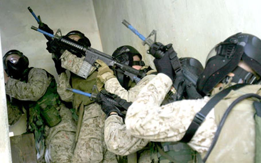 Marines from Combined Assault Battalion employ basic infantry tactics Thursday to ensure the stairway is clear of enemy troops before moving to the second story of a building at Combat Town on Camp Hansen.