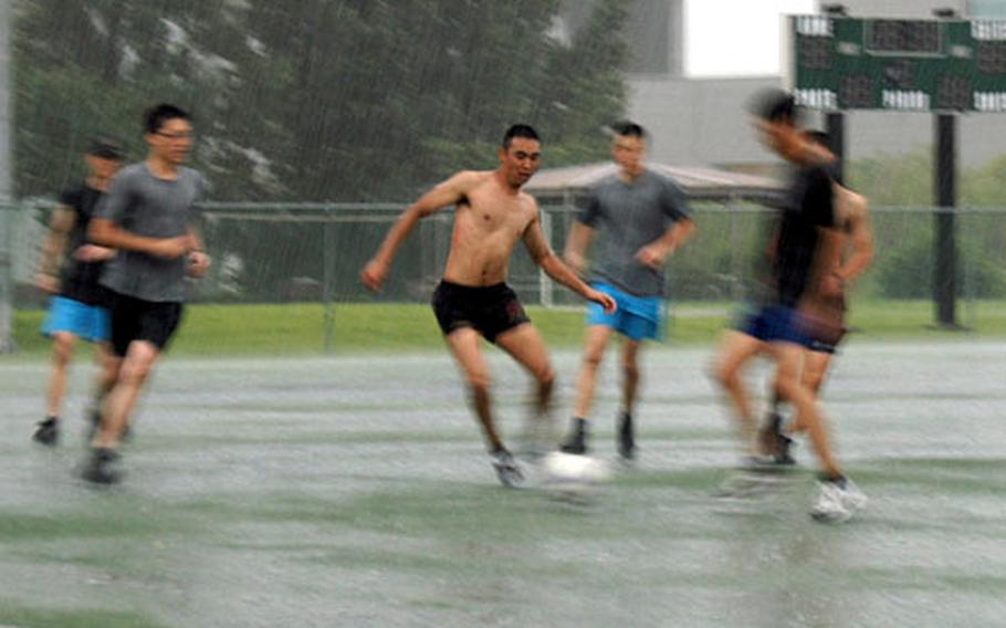 Thursday’s downpour didn’t stop a group of Korean Augmentees to the U.S. Army from playing soccer near Collier Field House on Yongsan Garrison.