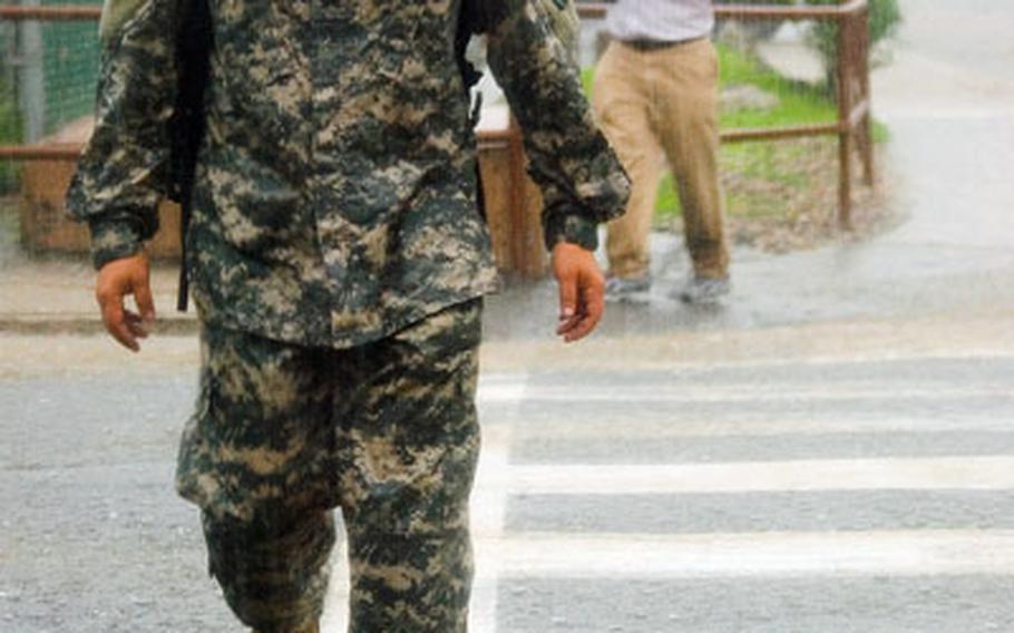 A soldier slogs through the rain at Yongsan Garrison.