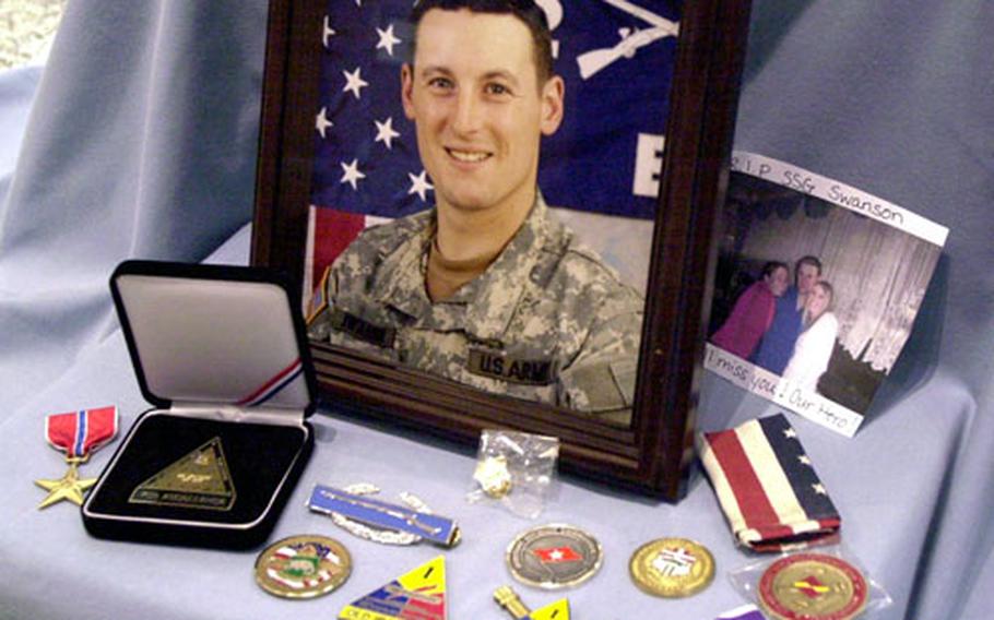 Commanders’ coins, a Combat Infantryman Badge and medals — including one of his two Purple Hearts — surround the photo of Staff Sgt. Chris Swanson after his memorial Friday at Good Samaritan Chapel in Baumholder, Germany. An admirer also placed a photo inscribed “RIP SSG Swanson, our hero. We’ll miss you.”