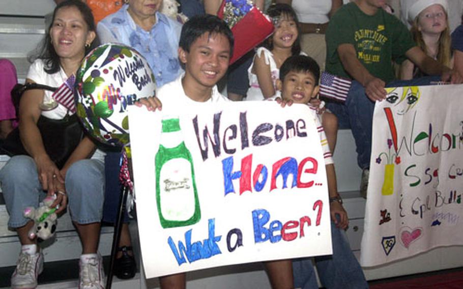 John Michael Caseja displays a welcome-home sign for his father, Spc. Johnathan Caseja, on Friday in Kaiserslautern, Germany.