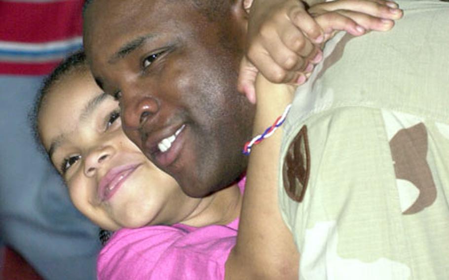 Staff Sgt. Guy Minott is greeted by his daughter Kyleigh, 6, on Friday morning at Kleber Kaserne.