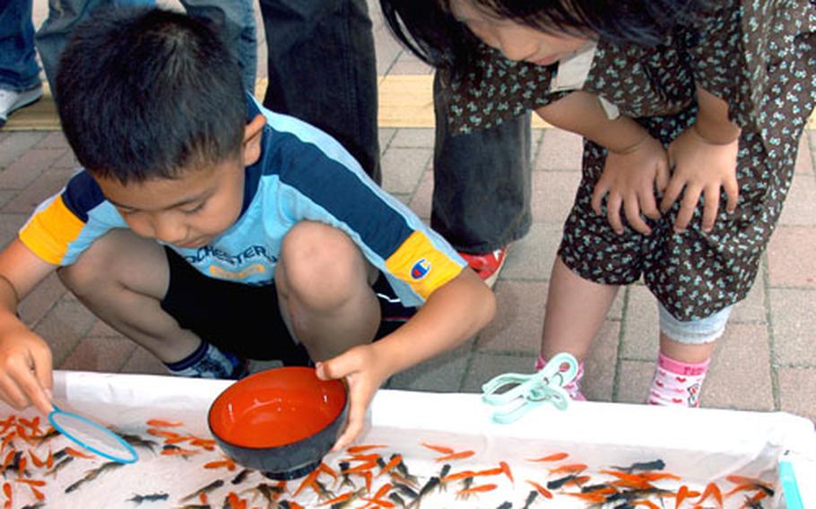 Catching goldfish in a bowl is one of many children’s games lining the streets outside Misawa Air Base for this weekend’s festival.
