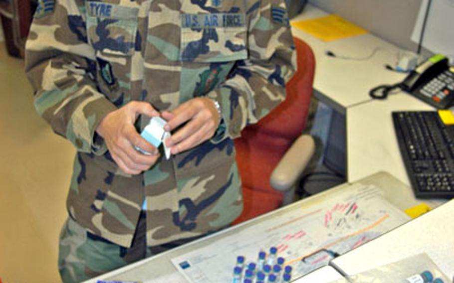 Senior Airman Kelley Tyre, a medical technician with the 35th Medical Group at Misawa Air Base, Japan, sorts through a shipment of the children’s hepatitis A vaccine.