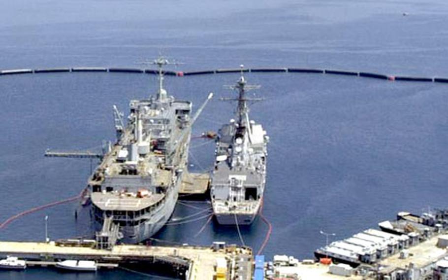 Submarine tender USS Emory S. Land, left, and an accompanying ship are moored alongside the pier at Naval Support Activity La Maddalena, on the northern tip of the Italian island of Sardinia. On Friday, U.S. and Italian defense officials announced the U.S. Navy will close the base and turn it over to Italian authorities by spring 2008.