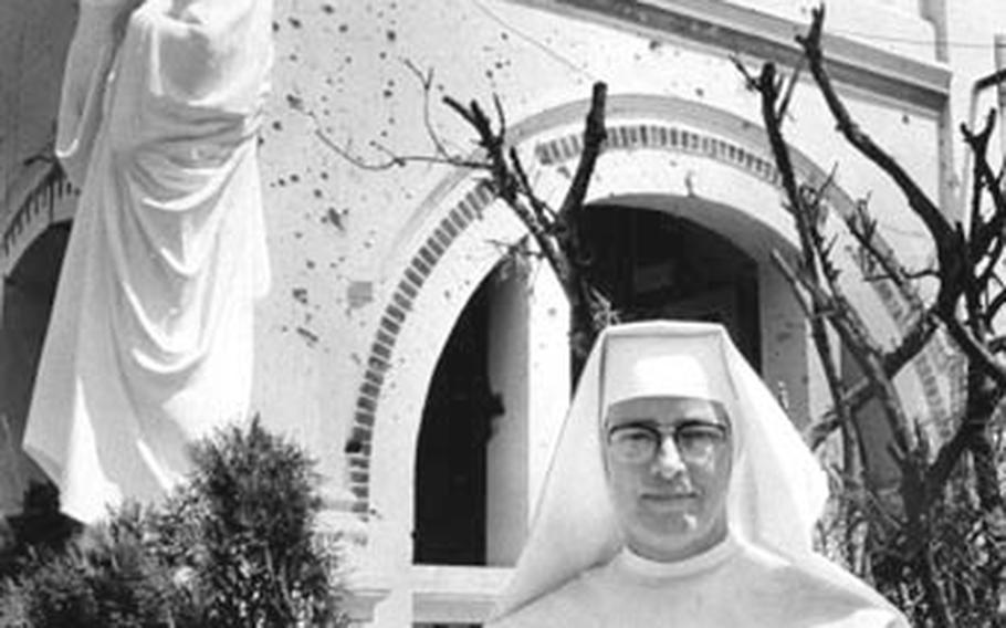 Sister Mary stands in front of the bullet-riddled entrance to the convent and school she oversees near the U.S. air base at Vinh Long
