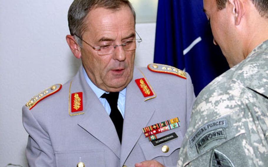 Staff Sgt. Jonathon Zapien, of the 3rd Special Forces Group at Ft. Bragg, N.C., receives the German Ehrenmedaille (Honor Medal) from Gen. Wolfgang Schneiderhan, the German chief of defense, at the German Ministry of Defense in Berlin on Tuesday.