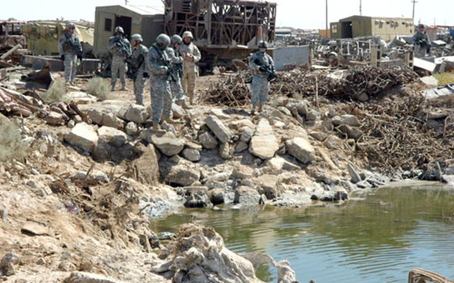 Soldiers from the 1st Battalion, 17th Infantry Regiment, 172nd Stryker Brigade Combat Team examine a lagoon in a junkyard during an operation in Shab on Thursday.