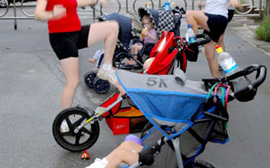 Participants in Stroller Strides do warm-up exercises Thursday in a circle of strollers before heading out on a power walk peppered with body-toning intervals using resistance bands. Mothers meet at Kadena Air Base, Okinawa, to exercise together with their children.