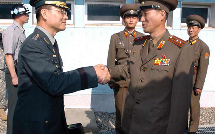 South Korean delegation chief Col. Moon Sung-mook, third from left, is greeted by an unidentified North Korean officer upon his arrival at the North side of Panmunjom on Monday.